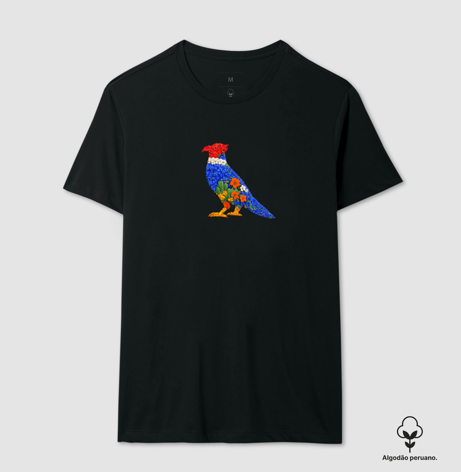 A força e a beleza do sertão nordestino ganham vida nesta estampa, onde o carcará — símbolo de coragem e resistência — apresenta o esplendor das flores que brotam mesmo em meio à aridez. - Camiseta Algodão Peruano
